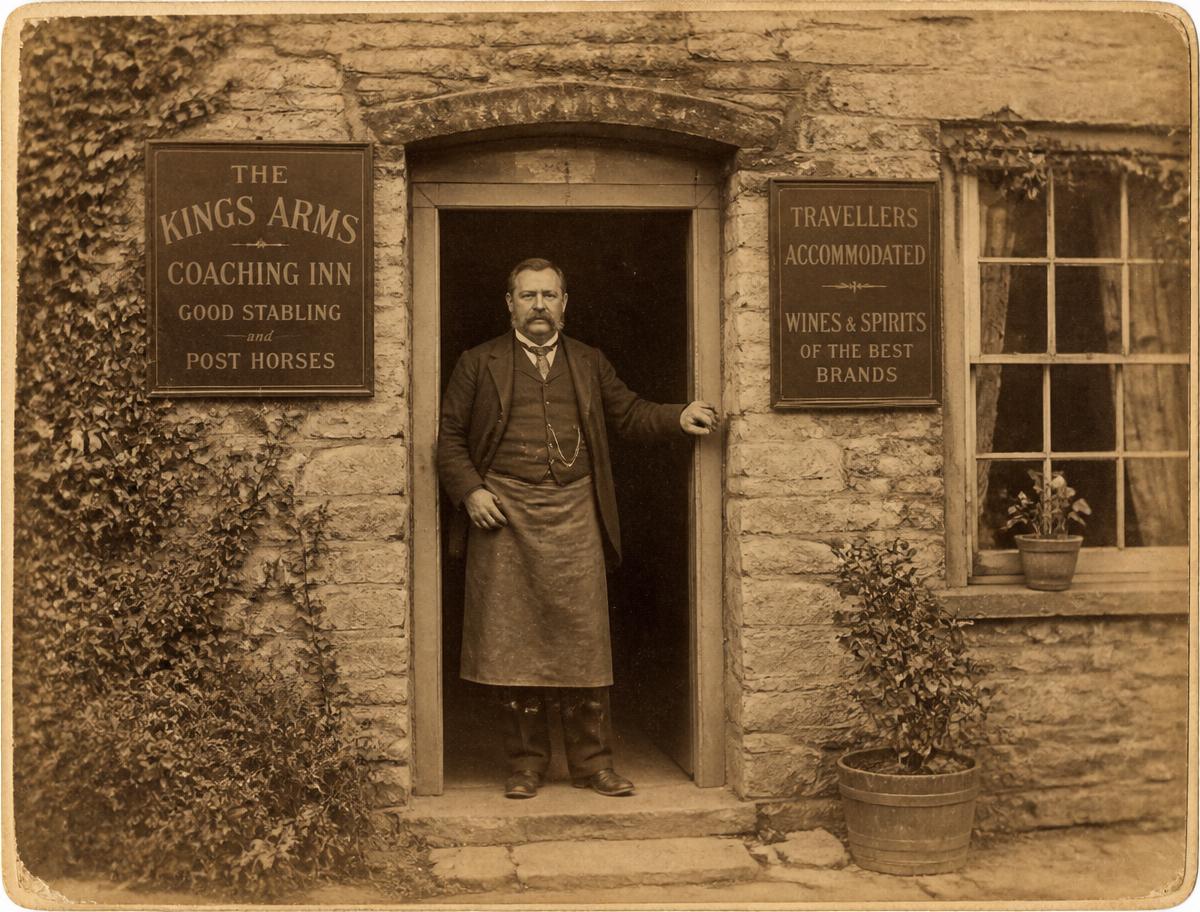 Archive photograph of a Victorian innkeeper in the doorway of a coaching inn
